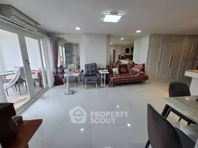 Spacious living room with modern decor and large windows leading to a balcony.