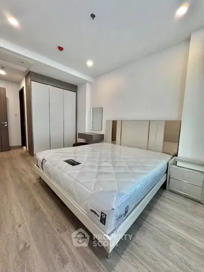 Modern bedroom with sleek design, featuring a comfortable bed, stylish wardrobe, and elegant flooring.
