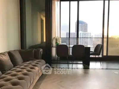 Luxurious living room with elegant sofa and stunning city view through large windows.