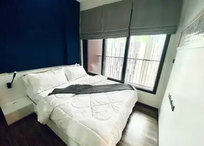 Modern bedroom with large window and stylish decor in urban apartment