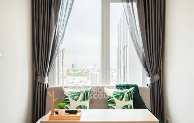 Chic living room with city view, elegant curtains, and stylish decor.