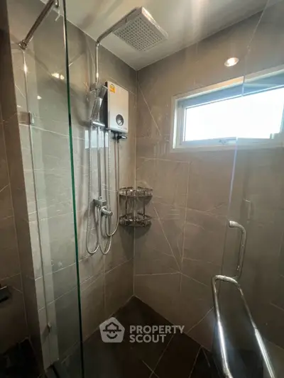 Modern bathroom with sleek shower and glass enclosure in contemporary home.