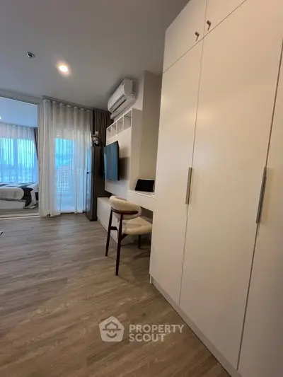 Modern apartment interior with sleek furniture and large windows offering natural light.