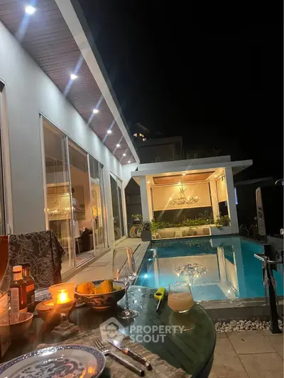 Luxurious modern villa with private pool and elegant outdoor dining area at night.