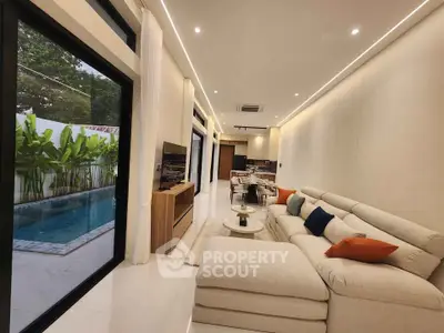 Luxurious open-plan living room with pool view and modern decor
