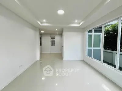 Spacious modern living room with large windows and sleek tile flooring