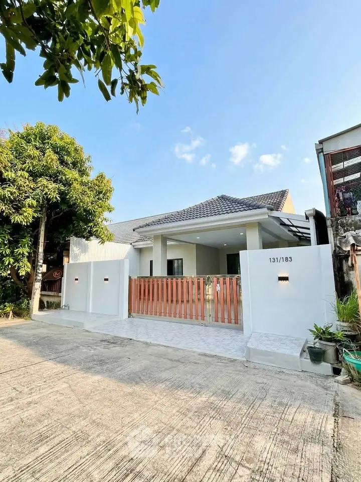 Charming single-story home with modern facade and spacious driveway in a serene neighborhood.