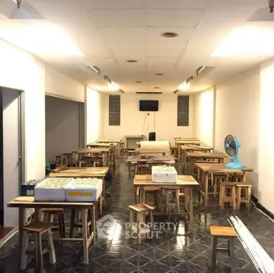 Spacious dining area with wooden tables and stools, ideal for gatherings or events.