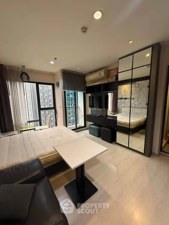 Modern studio apartment with mirrored wardrobe and city view balcony