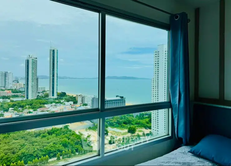Stunning high-rise bedroom view with expansive cityscape and ocean panorama.