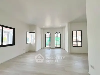 Spacious living room with elegant arched windows and abundant natural light.