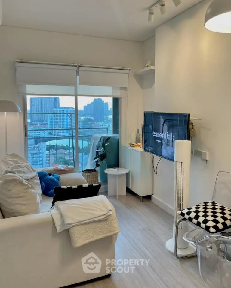 Modern living room with city view, stylish decor, and cozy seating area in a high-rise apartment.