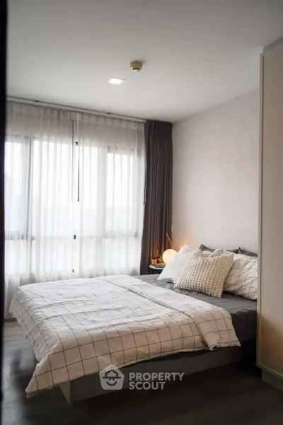 Cozy modern bedroom with large window and stylish decor