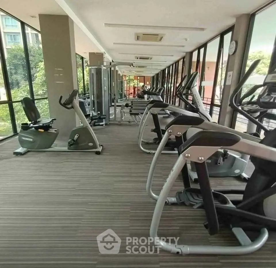 Modern gym with state-of-the-art equipment and large windows offering scenic views.