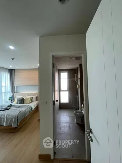 Modern bedroom with ensuite bathroom, featuring sleek design and natural light.