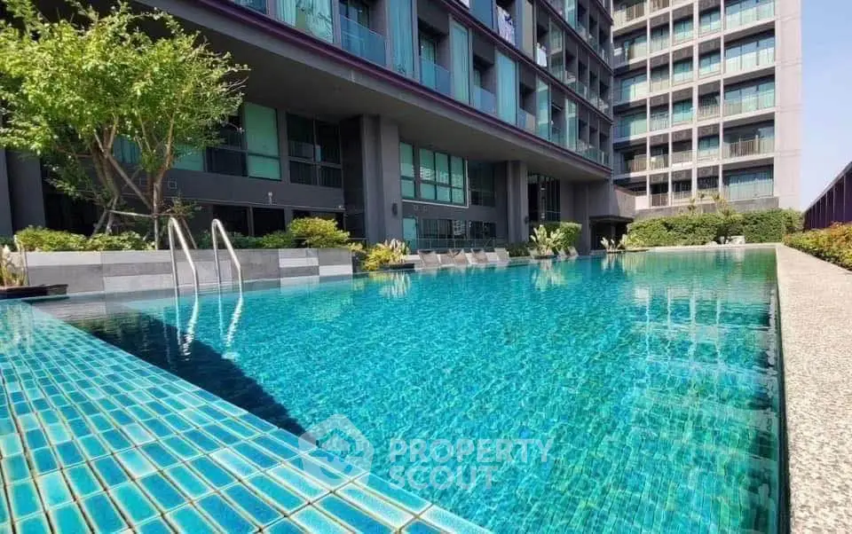 Luxurious apartment building with a stunning outdoor pool and modern architecture.
