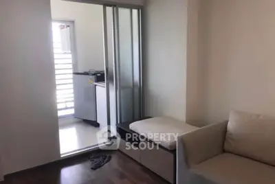 Cozy living room with sliding door leading to a bright balcony area.