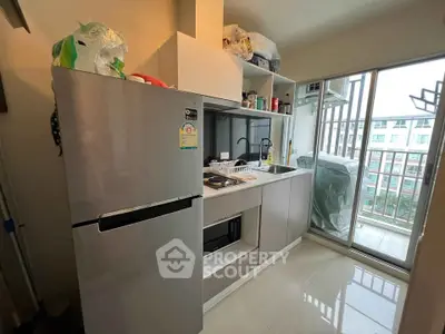 Modern kitchen with sleek appliances and balcony view in urban apartment