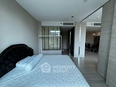 Spacious modern bedroom with elegant decor and large window for natural light.