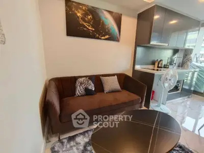 Modern living room with cozy sofa and sleek kitchen area in open layout apartment.