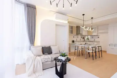Modern open-plan living room with stylish decor and dining area in a bright apartment.