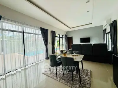 Spacious living room with pool view and elegant dining setup