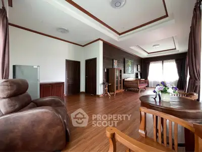 Spacious living room with elegant wooden flooring and cozy seating area.