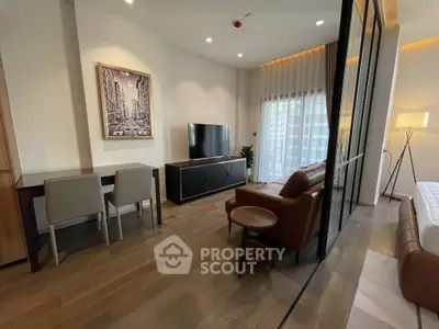 Modern living room with sleek furniture and large TV, featuring a stylish open layout.
