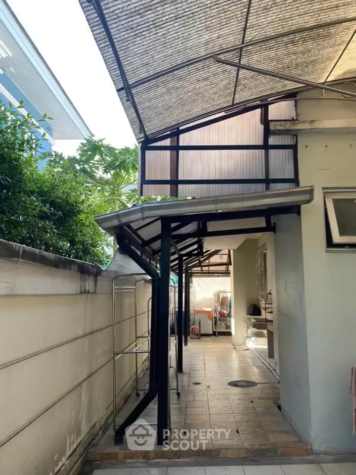 Charming outdoor patio with covered walkway and tiled flooring, perfect for relaxation and entertaining.