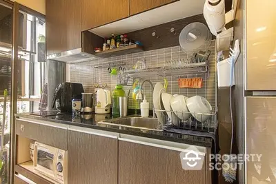 Modern kitchen with sleek cabinetry and appliances, featuring a cozy and efficient layout.