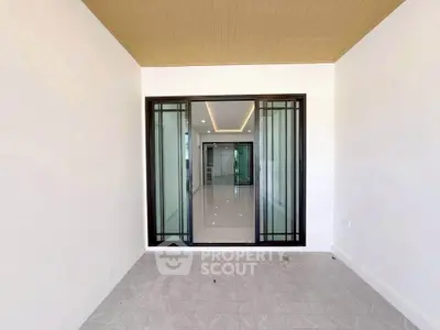 Spacious modern interior with sliding glass doors and elegant ceiling lighting.