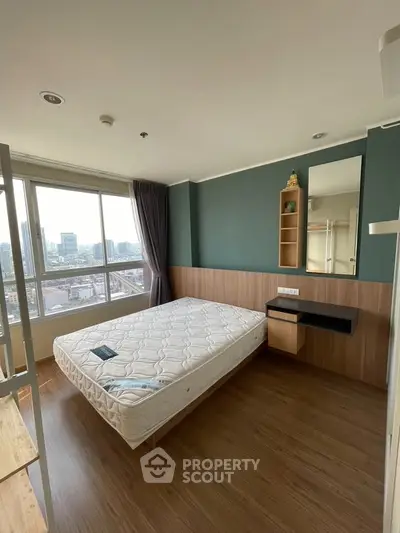 Modern bedroom with large window and city view, featuring a comfortable bed and stylish decor.