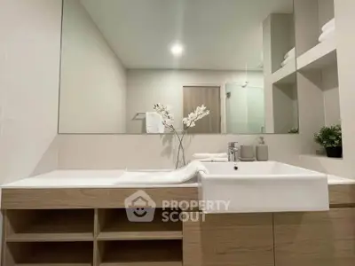 Modern bathroom with sleek vanity and large mirror in a contemporary home.