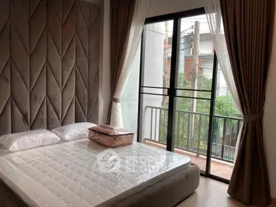 Modern bedroom with large window and balcony view, featuring stylish wall paneling and natural light.