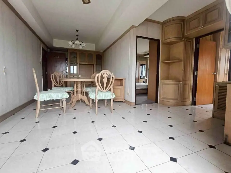 Spacious dining area with elegant wooden furniture and tiled flooring in a modern apartment.