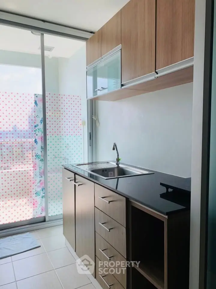 Modern kitchen with sleek cabinetry and balcony view, perfect for urban living.