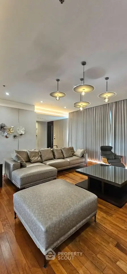 Luxurious living room with elegant lighting and plush seating on wooden flooring.