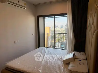 Modern bedroom with city view and large window in high-rise apartment