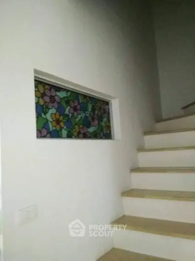 Charming staircase with colorful stained glass window in modern home