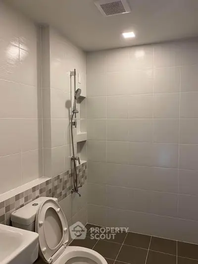 Modern bathroom with sleek tiles and shower, perfect for a contemporary home.