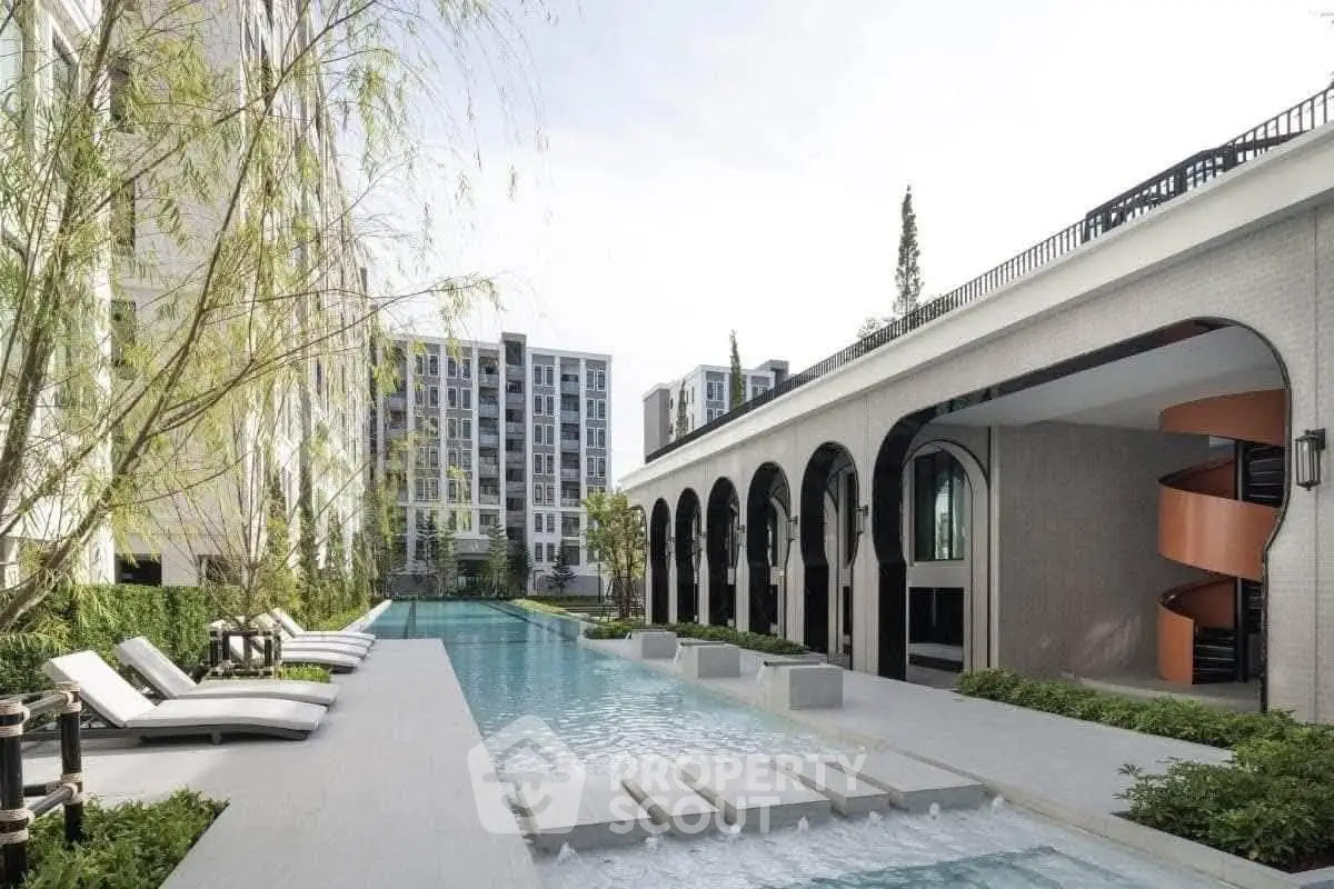 Luxurious modern apartment complex with elegant pool and stylish architecture, perfect for upscale living.