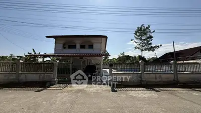 Charming two-story house with spacious driveway and lush greenery, perfect for family living.