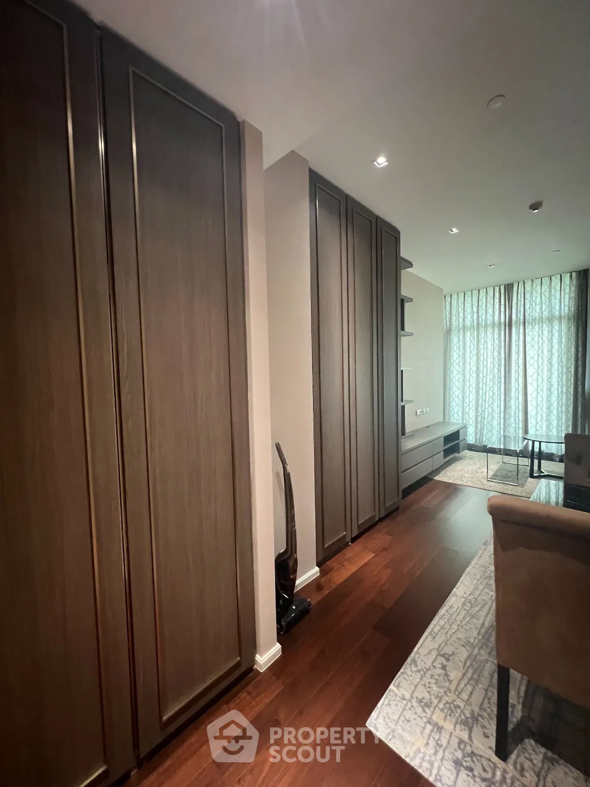 Spacious living room with elegant wooden flooring and modern furnishings, perfect for relaxation and entertainment.