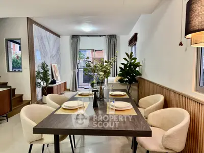 Modern dining area with elegant table setting and cozy chairs in a stylish open-plan living space.