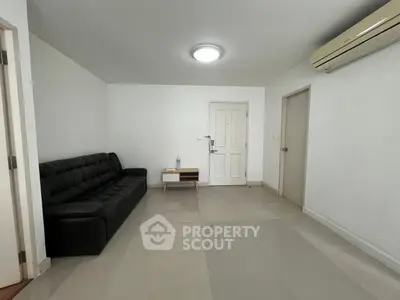 Spacious living room with modern sofa and air conditioning in a minimalist apartment.