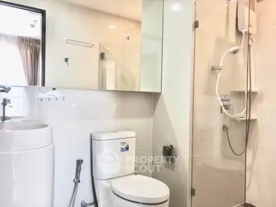 Modern bathroom with glass shower and sleek fixtures in a contemporary apartment.