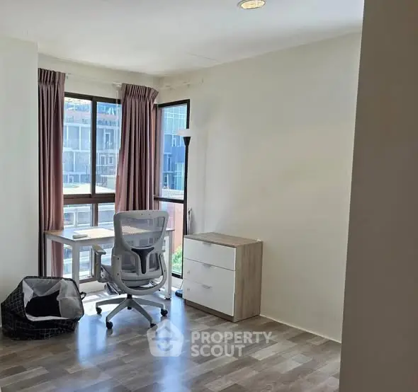 Bright study room with modern desk and ergonomic chair, featuring large windows and stylish flooring.