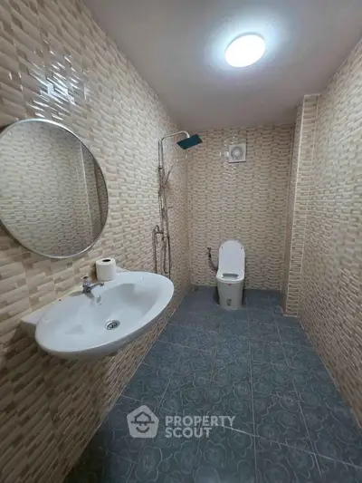 Modern bathroom with stylish tiles and round mirror