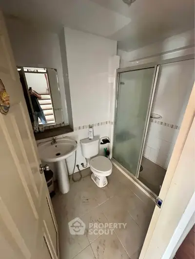 Compact bathroom with shower and modern fixtures in cozy apartment.