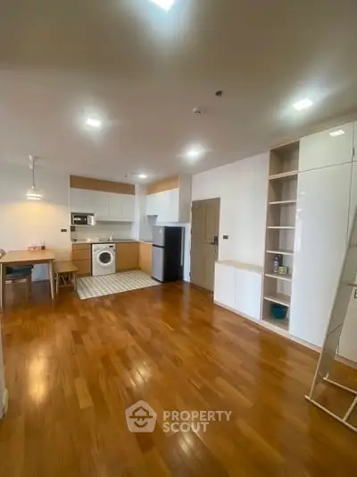 Spacious kitchen with wooden flooring and modern appliances in open layout